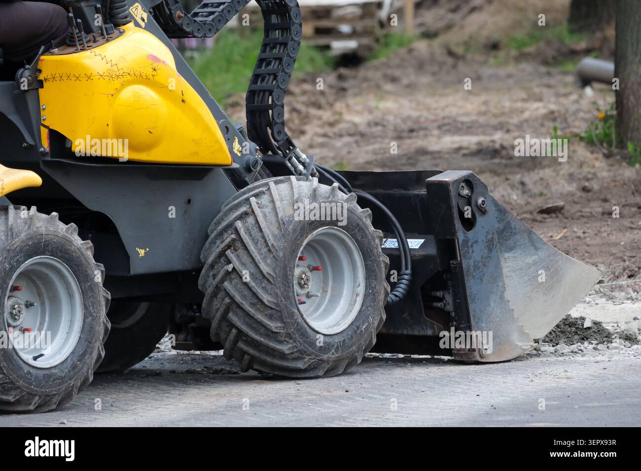 Eine kleine gelbe Maschine entfernt Schmutz und Ablagerungen auf einer Baustelle. Kiew, Ukraine, 16. Juni 2026 Stockfoto