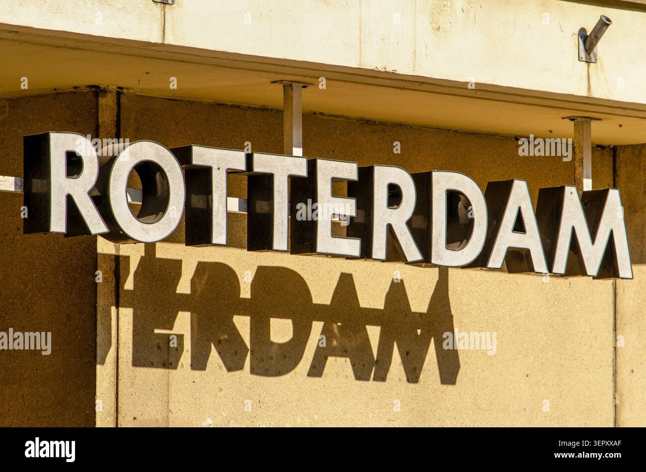 Schild mit dem Namen Rotterdam, der einen Schatten auf die Fassade dahinter wirft Stockfoto