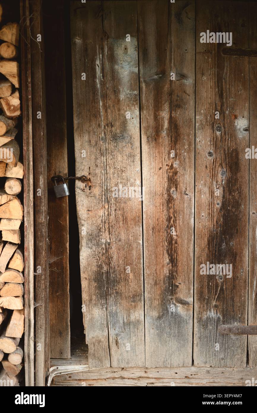 Alte Holztür mit rustikaler Textur in natürlichem Licht. Vintage Hintergrund mit verwitterter Oberfläche und ländlicher Atmosphäre Stockfoto