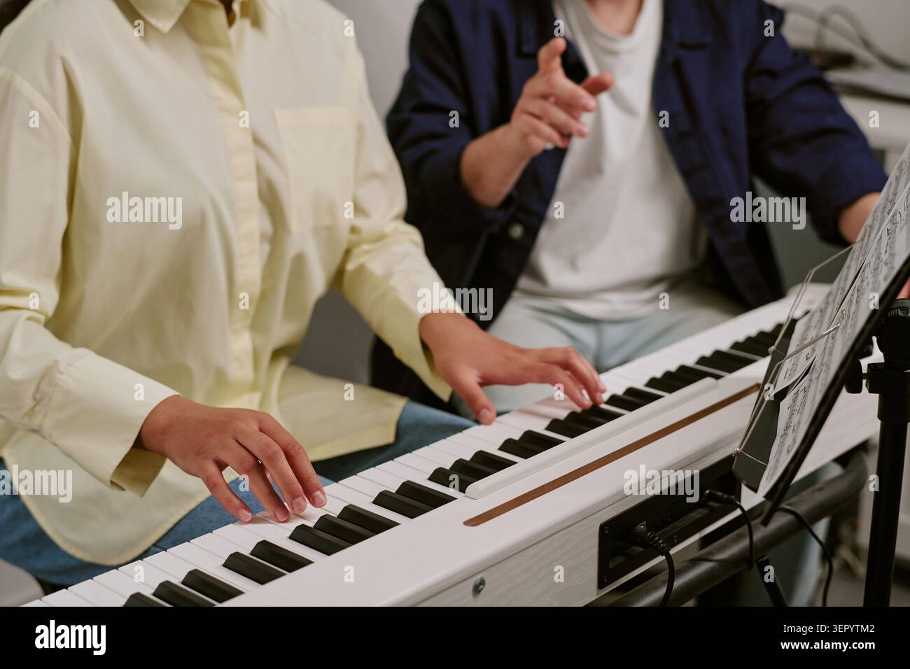 Teenager, der während des Musikunterrichts mit dem Lehrer Digital Piano spielt Stockfoto