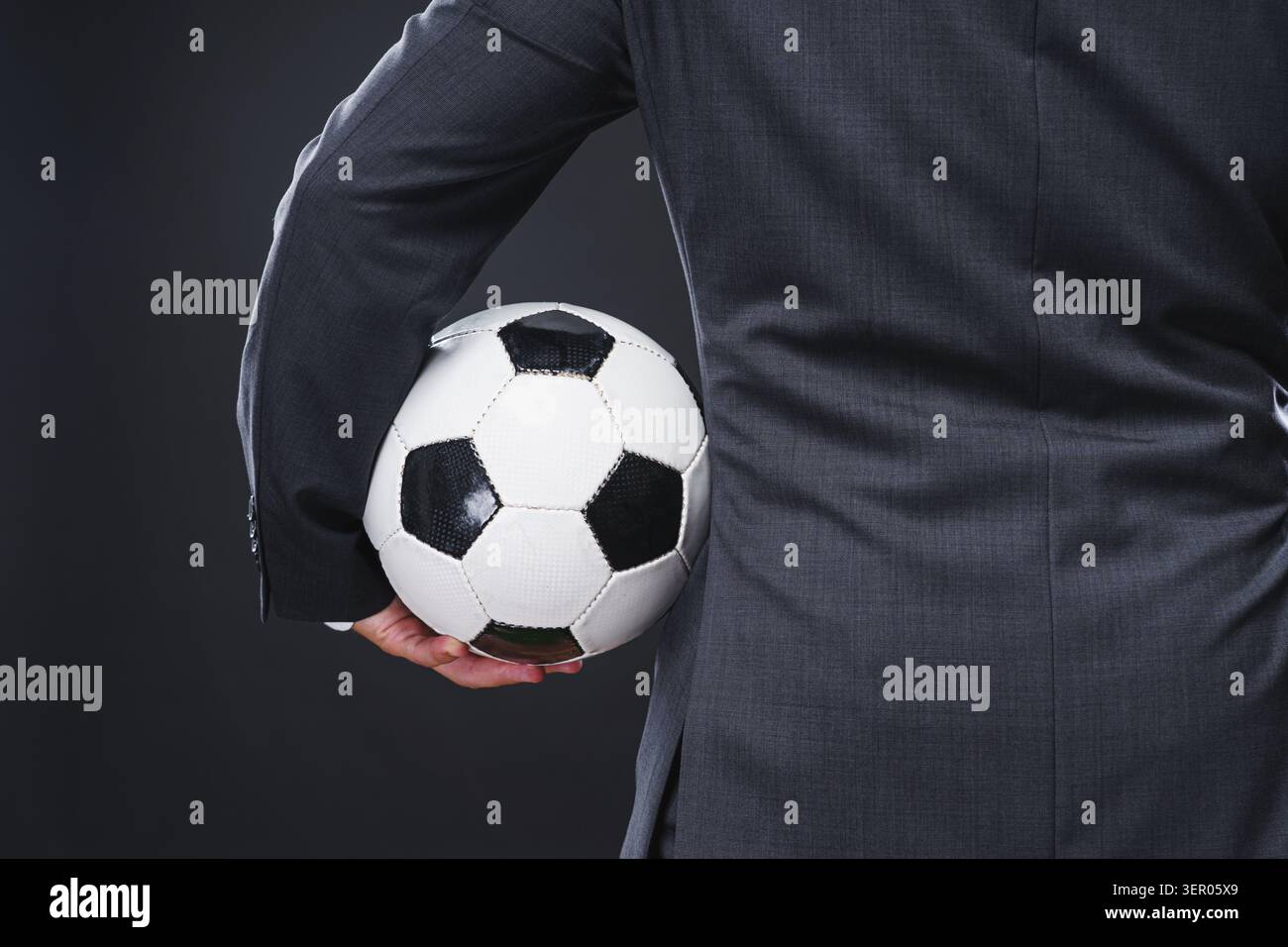 Ein sportlicher Mann in elegantem Anzug mit dem Fußball-Trainer- oder Profispieler-Konzept Stockfoto
