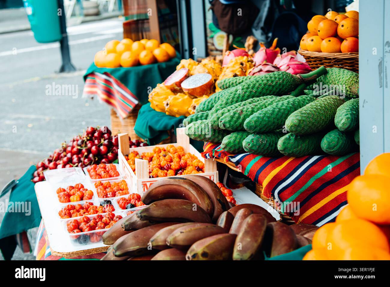 Eine lebhafte Nahaufnahme einer exotischen Obstpräsentation im Freien auf einem traditionellen Markt auf Madeira, Portugal. Der Stand bietet einzigartige regionale Spezialität Stockfoto