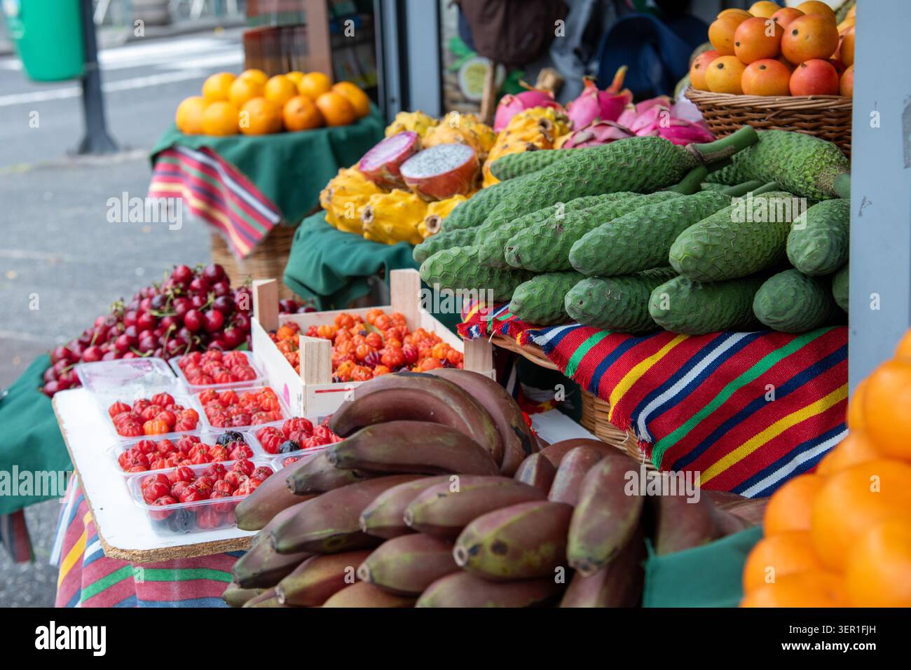 Eine lebhafte Nahaufnahme einer exotischen Obstpräsentation im Freien auf einem traditionellen Markt auf Madeira, Portugal. Der Stand bietet einzigartige regionale Spezialität Stockfoto