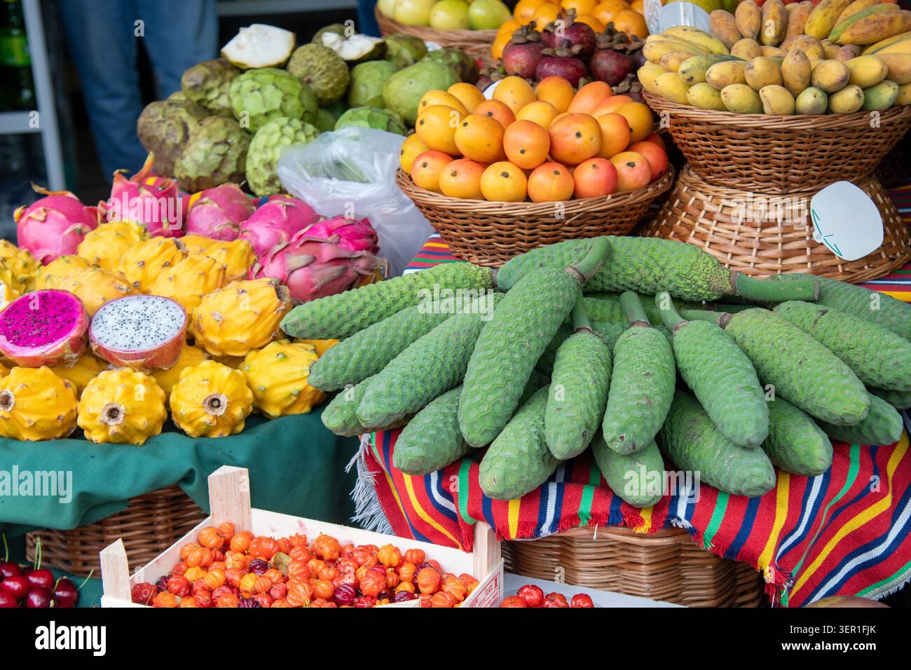 Eine lebhafte Nahaufnahme einer exotischen Obstpräsentation im Freien auf einem traditionellen Markt auf Madeira, Portugal. Der Stand bietet einzigartige regionale Spezialität Stockfoto