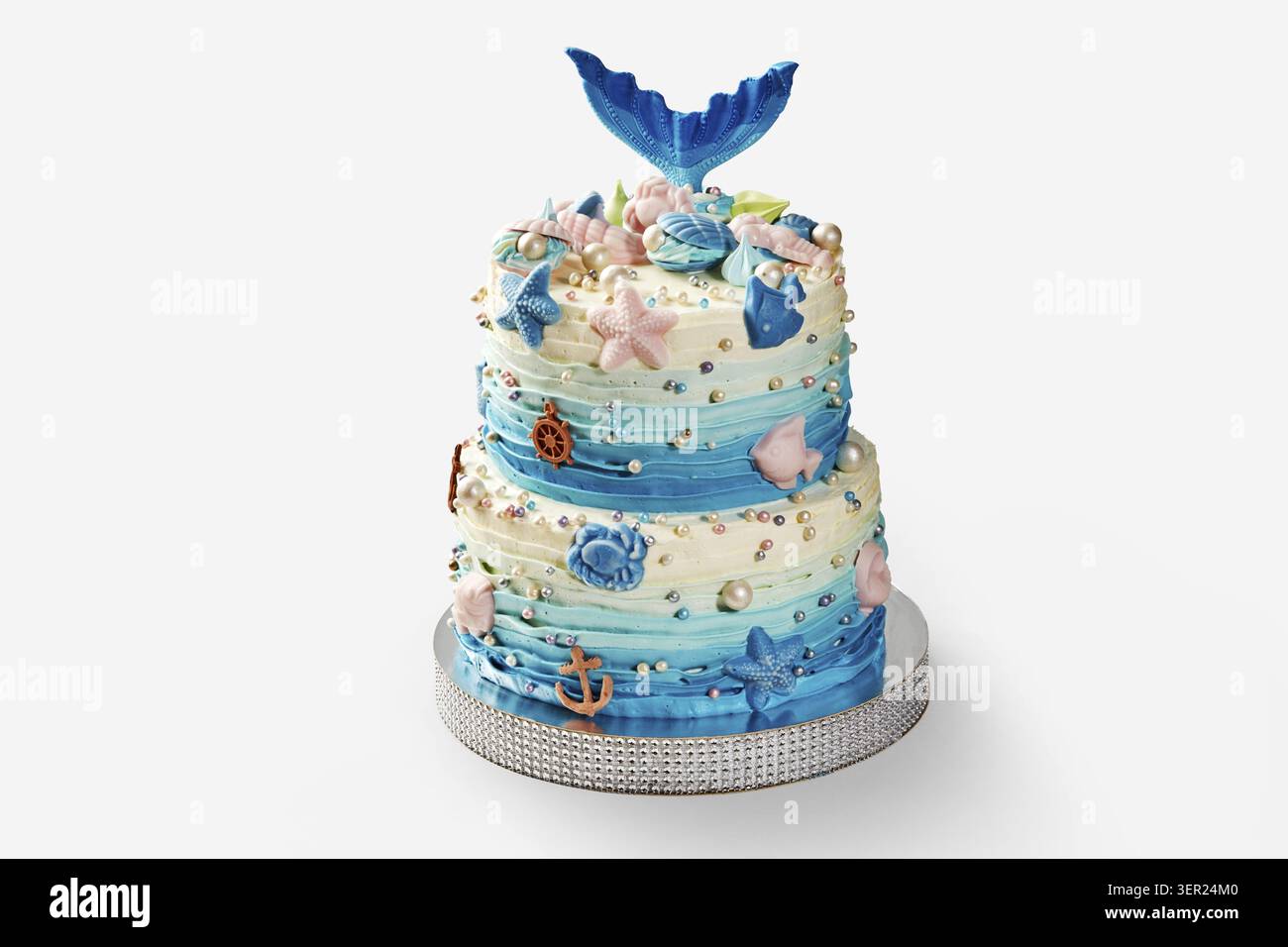 Zweistufiger Kuchen mit essbarem Meerjungfrauenschwanz, Muscheln, Seesternen, Perlen und einem Anker, der ein skurriles Unterwasser-Thema schafft Stockfoto