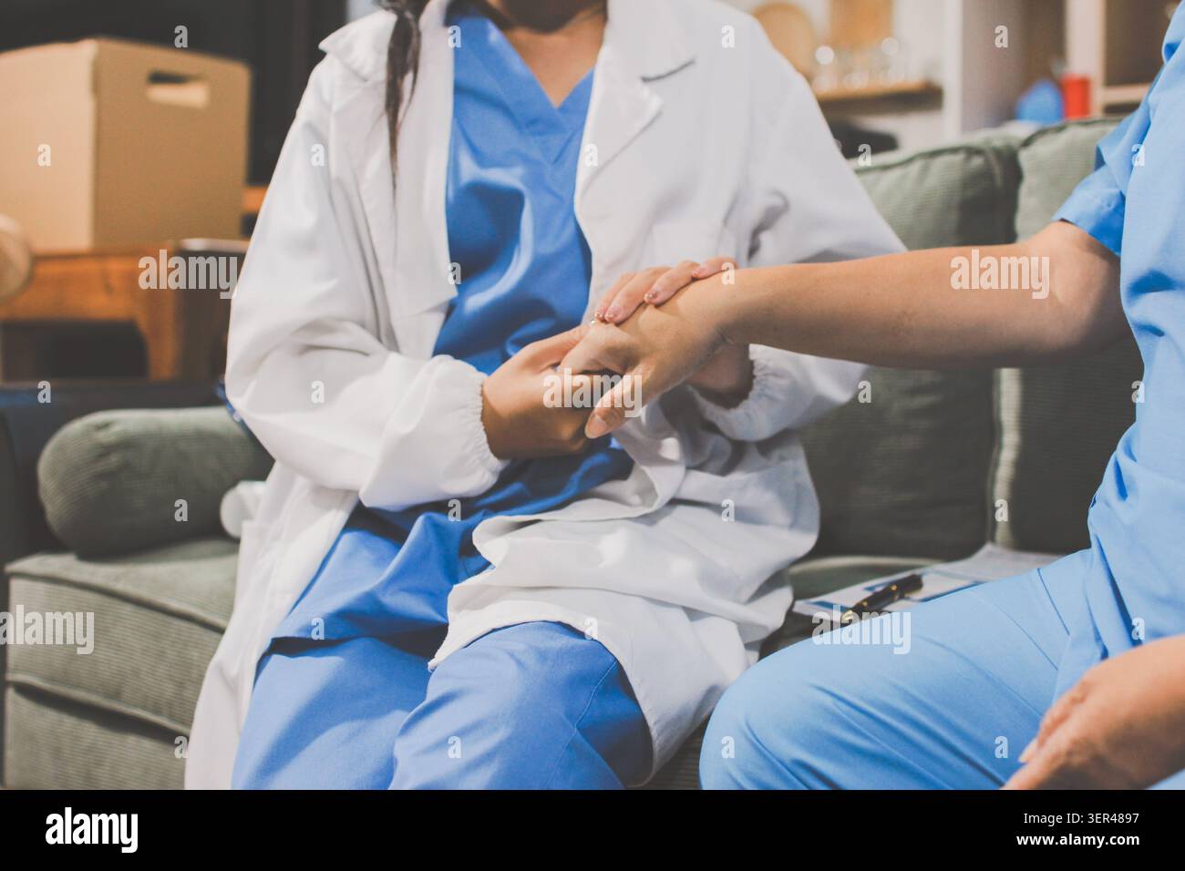 Der mitfühlende Gesundheitsdienstleister hält die Hand eines älteren Patienten, um Unterstützung und Komfort zu bieten. Stockfoto