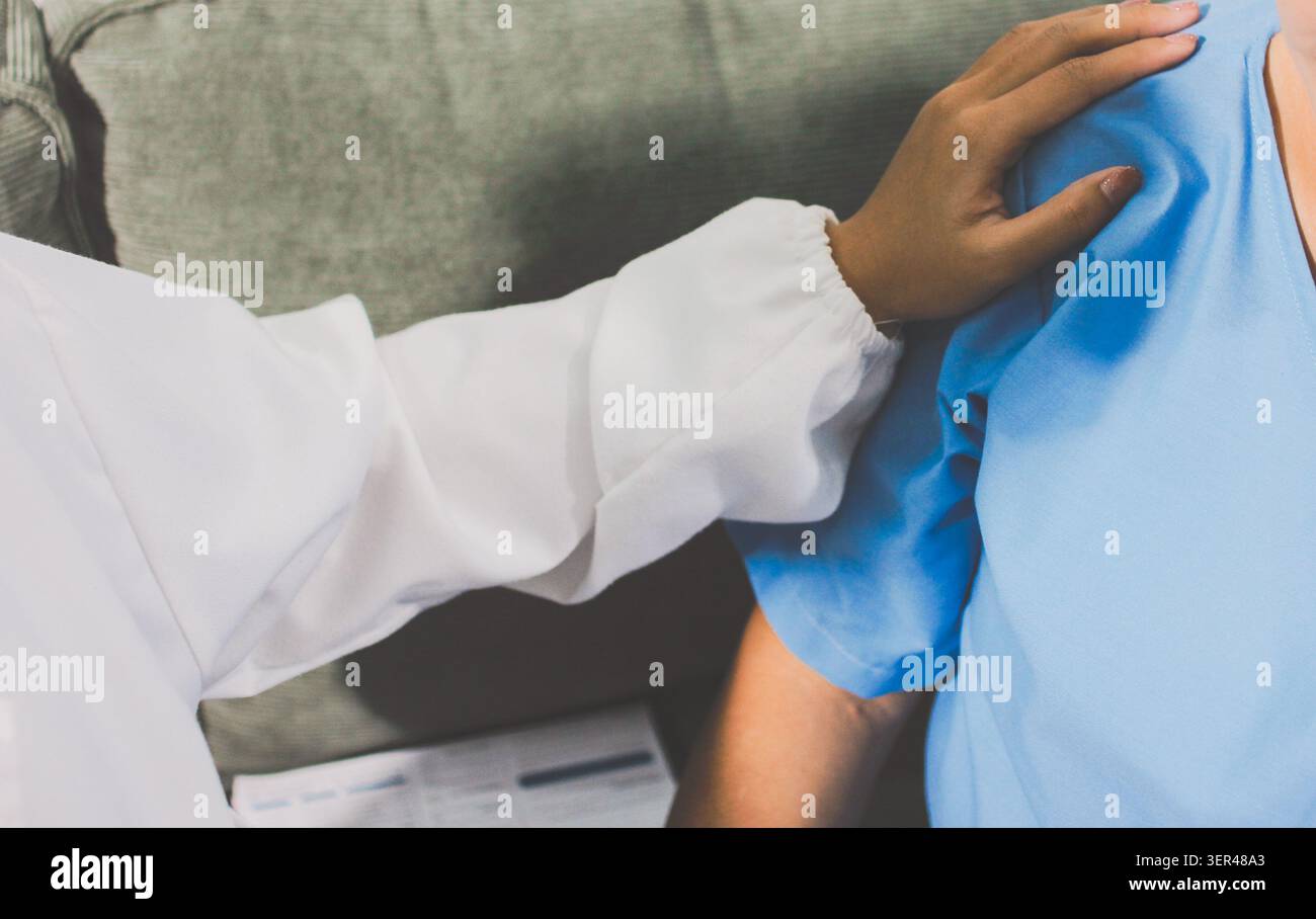 Der mitfühlende Gesundheitsdienstleister hält die Hand eines älteren Patienten, um Unterstützung und Komfort zu bieten. Stockfoto
