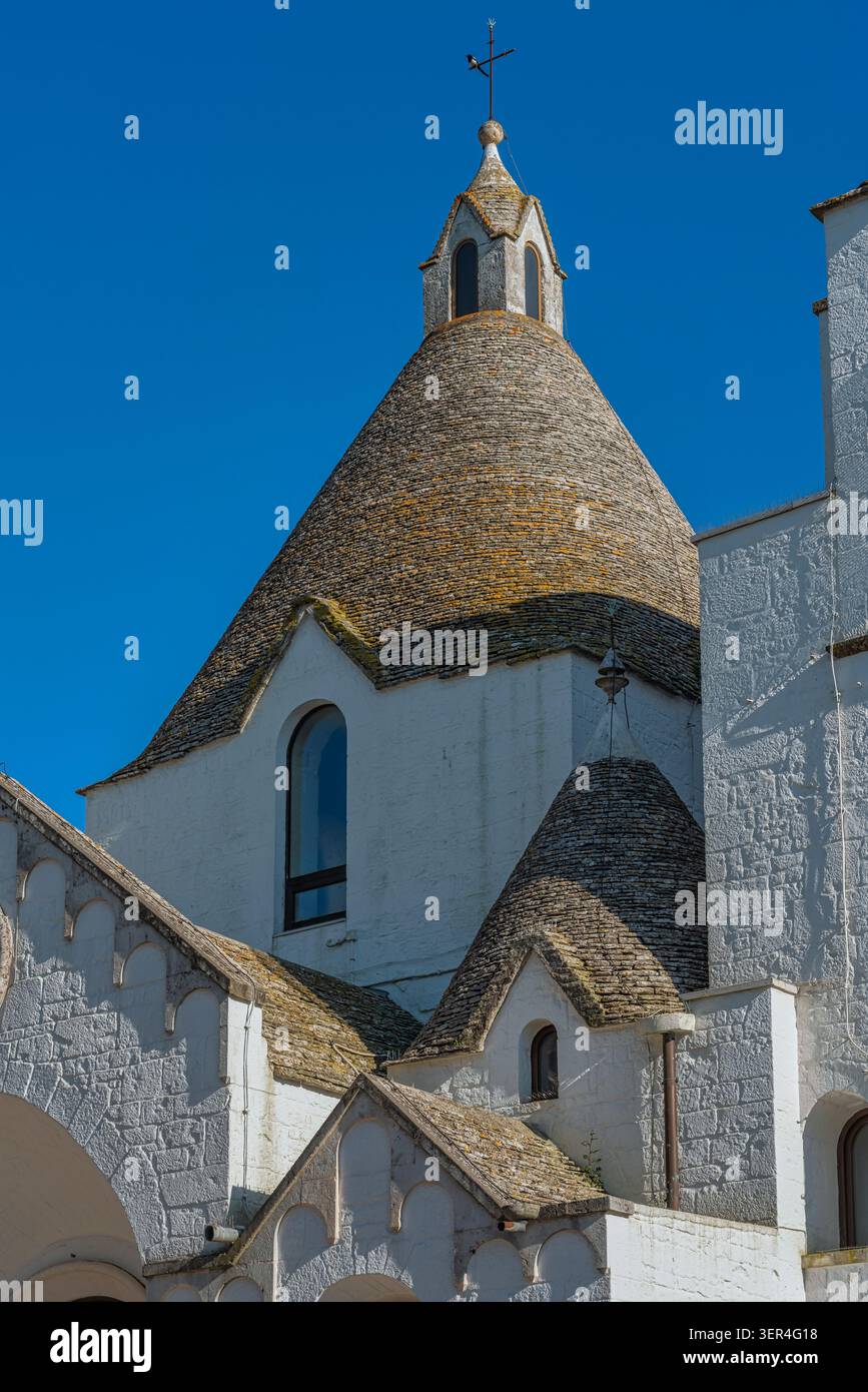 Touristen besuchen die Kirche St. Antonius von Padua, ein einzigartiges Gebäude in trullo-Form und ein architektonisches Wahrzeichen in Alberobello. Apulien Stockfoto