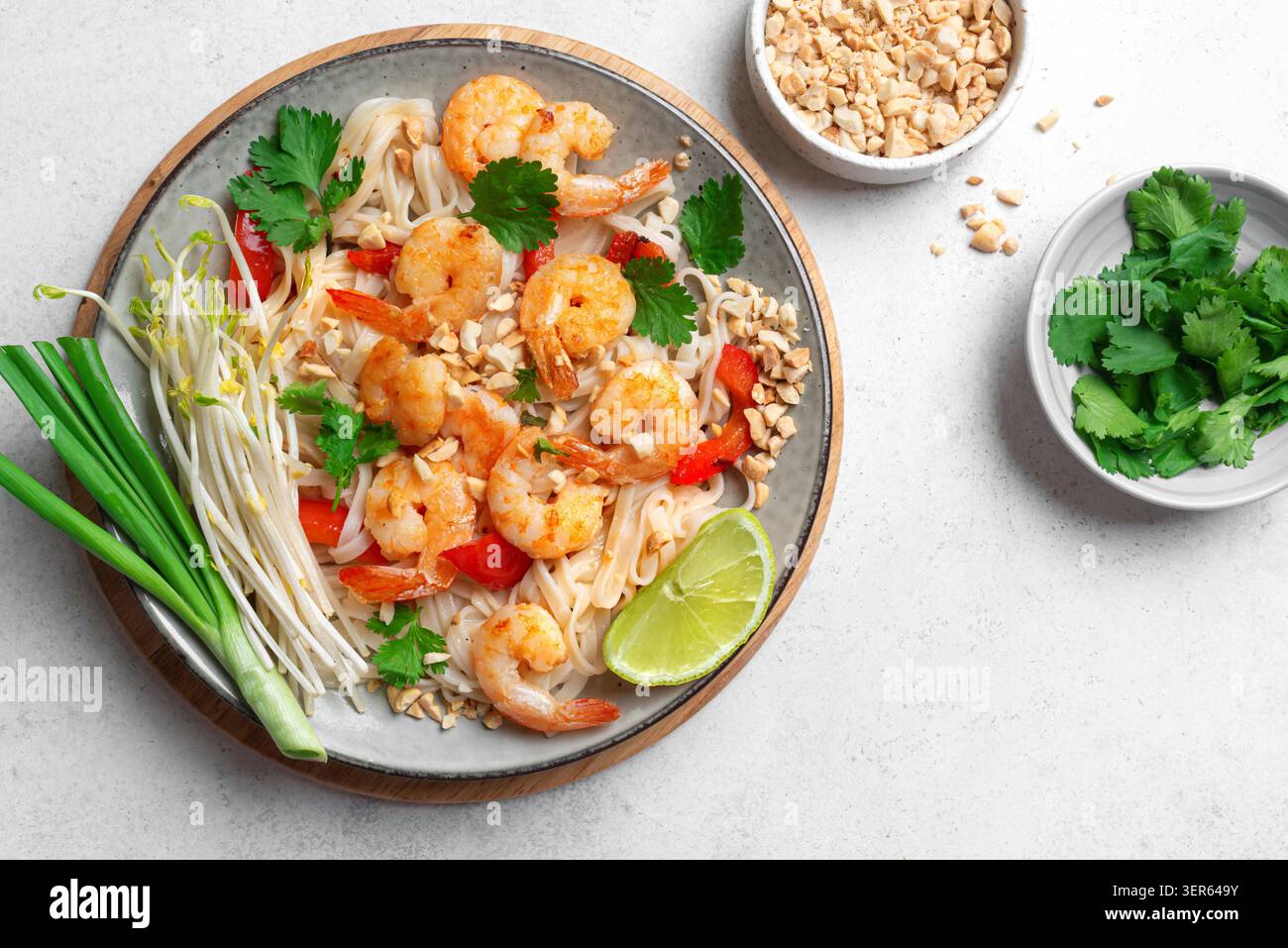 Authentische Thai Shrimps Pad Thai Nudeln mit Shrimps, Garnelen, gemahlenen Erdnüssen, Sojasprossen, Koriander und Limette. Traditionelle thailändische Mahlzeit, frittierte Meeresfrüchte-Nudeln aus nächster Nähe, Blick von oben. Stockfoto