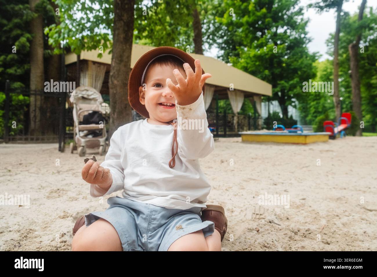 Kleinkind in Sun hat im Sandy Playground Park Stockfoto