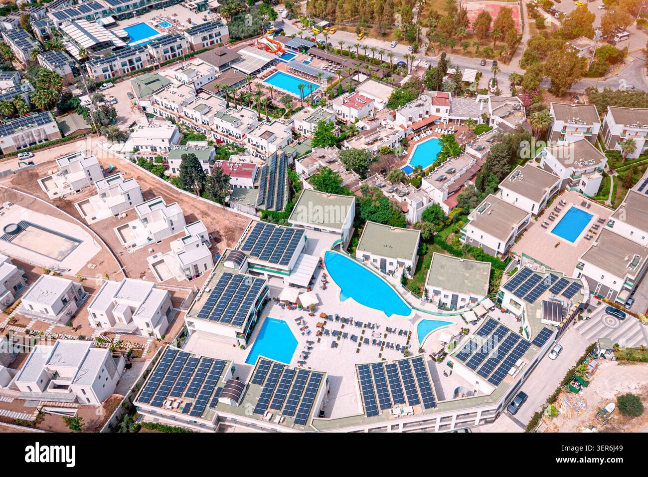 Resortkomplex mit verschiedenen Gebäuden mit Solarpaneelen, mehreren Swimmingpools und Grünflächen für nachhaltige Urlauber Stockfoto