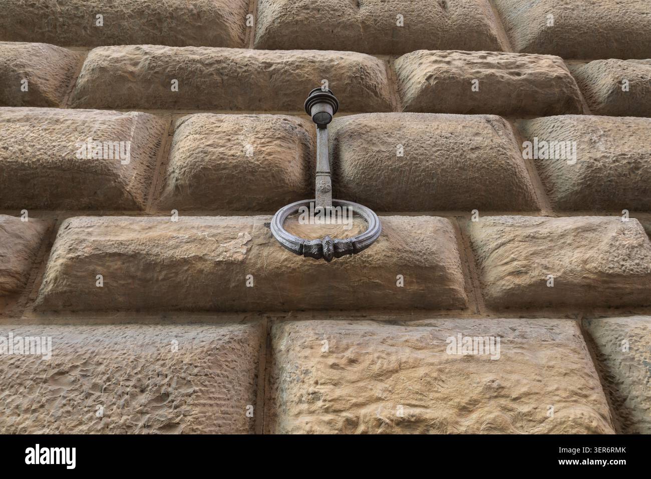 Antiker Metallhaken, Ferro da facciata auf strukturierten rustikalen Steinmauern mit architektonischem Detail Stockfoto