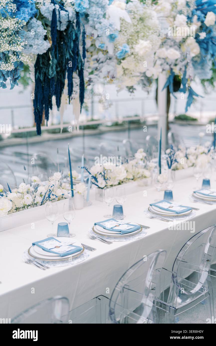 Eleganter Hochzeitsesstisch am Meer mit blauer und weißer Einrichtung Stockfoto