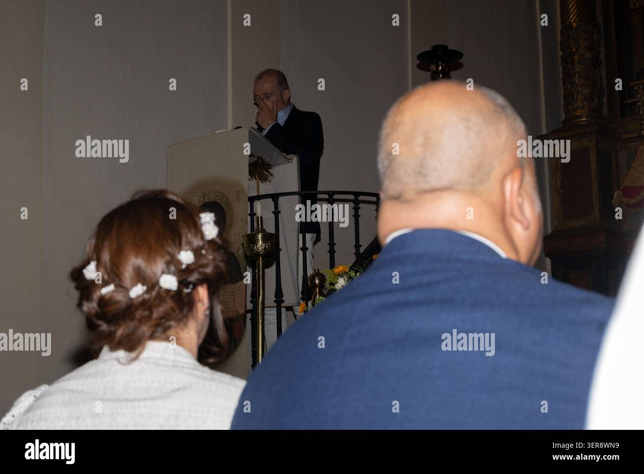 Leute hören einem Priester zu, der während eines Gottesdienstes von der Kanzel aus spricht Stockfoto