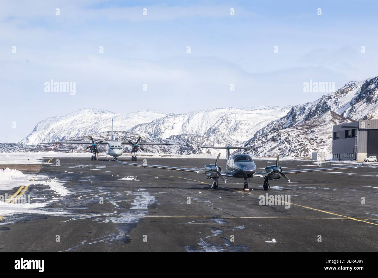 Kleine Propellerflugzeuge auf dem Asphalt am Flughafen Narsarsuaq mit schneebedeckten Bergen und winterlicher Luftfahrt, Narsarsuaq, Kujalleq, Grönland Stockfoto