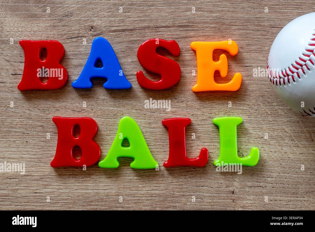 Bunte magnetische Buchstaben bilden Baseball auf einer Holzoberfläche mit einem Baseball Stockfoto