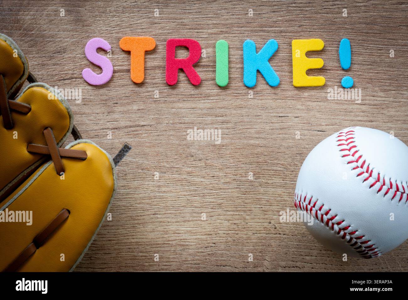 Baseballausrüstung und farbenfrohe Buchstaben treffen auf hölzernem Hintergrund Stockfoto