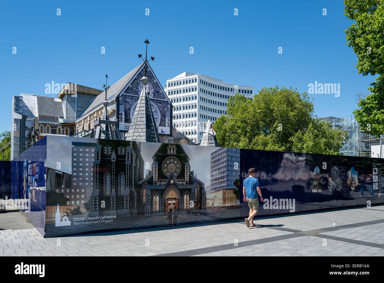 Ein Fußgänger geht an einem Bauwerk vorbei, das architektonische Renovationen des Wiedereinrichtungsprojekts in der Kathedrale von Christchurch zeigt. Stockfoto