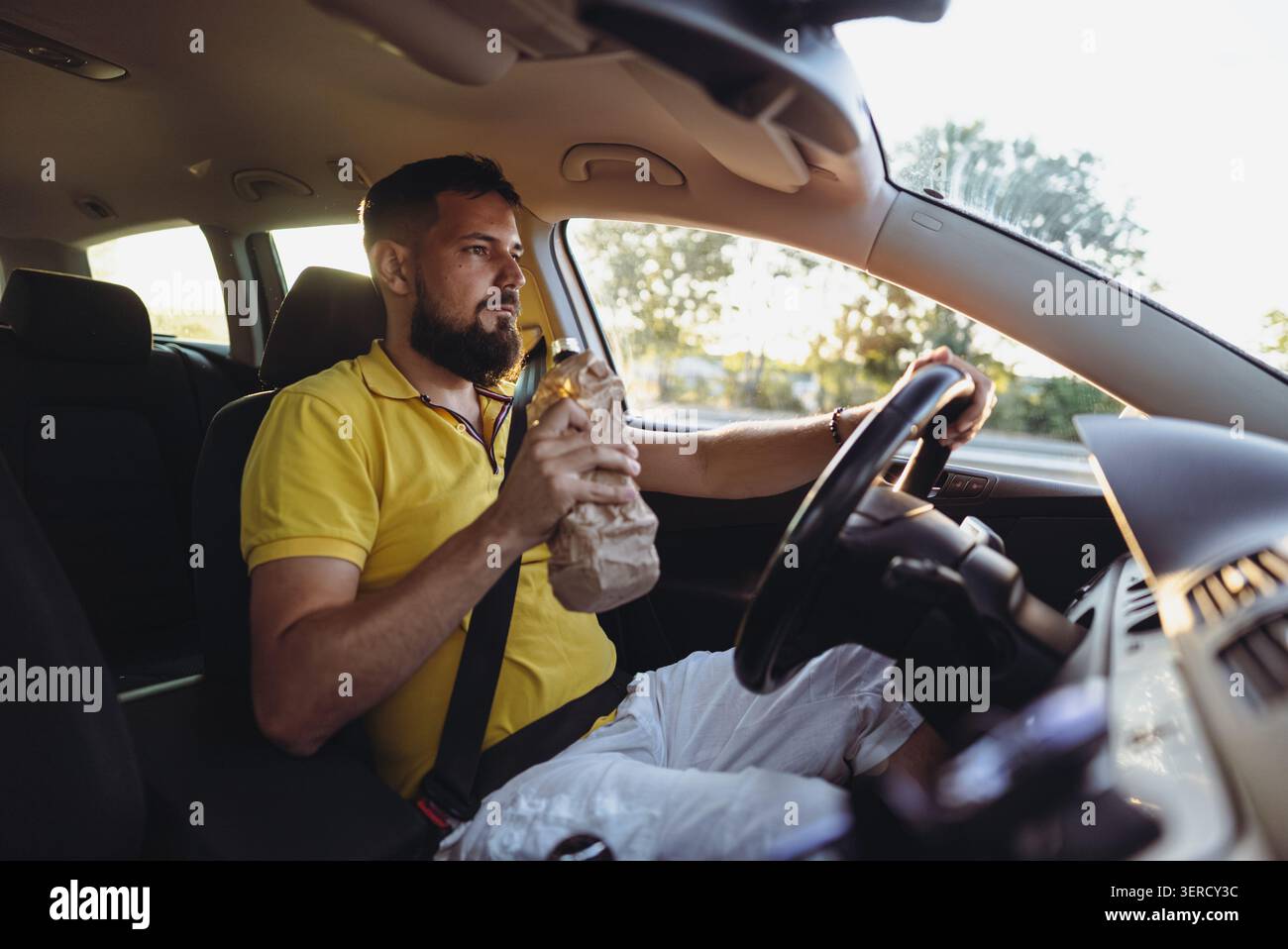 Gefahr auf der Straße. Mann Trinkt Während Der Fahrt Stockfoto