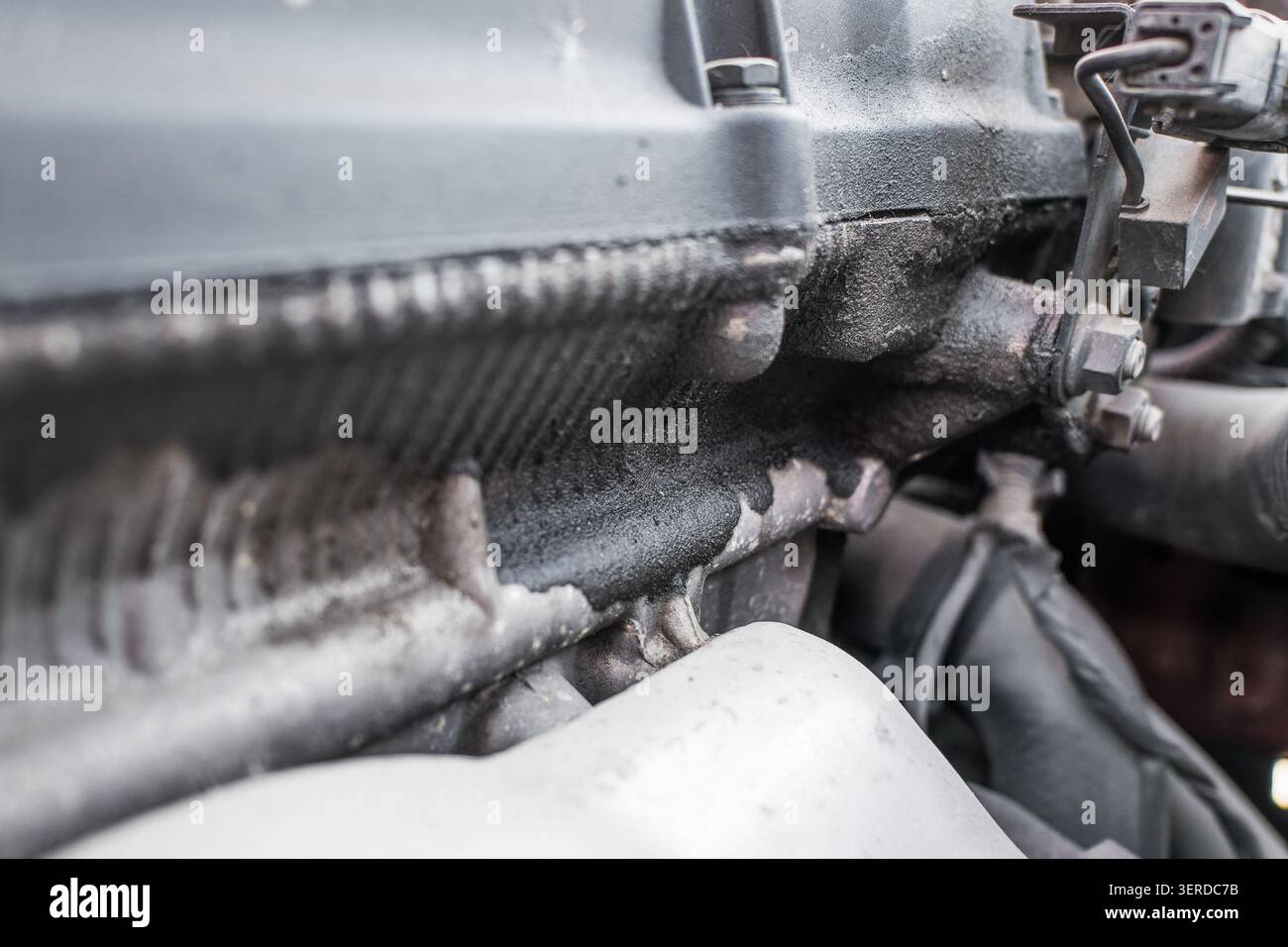 Ansicht eines beschädigten Motorblocks mit sichtbarem Ölsickern und Schmutz, die die Folgen alter Dichtungen verdeutlichen Stockfoto
