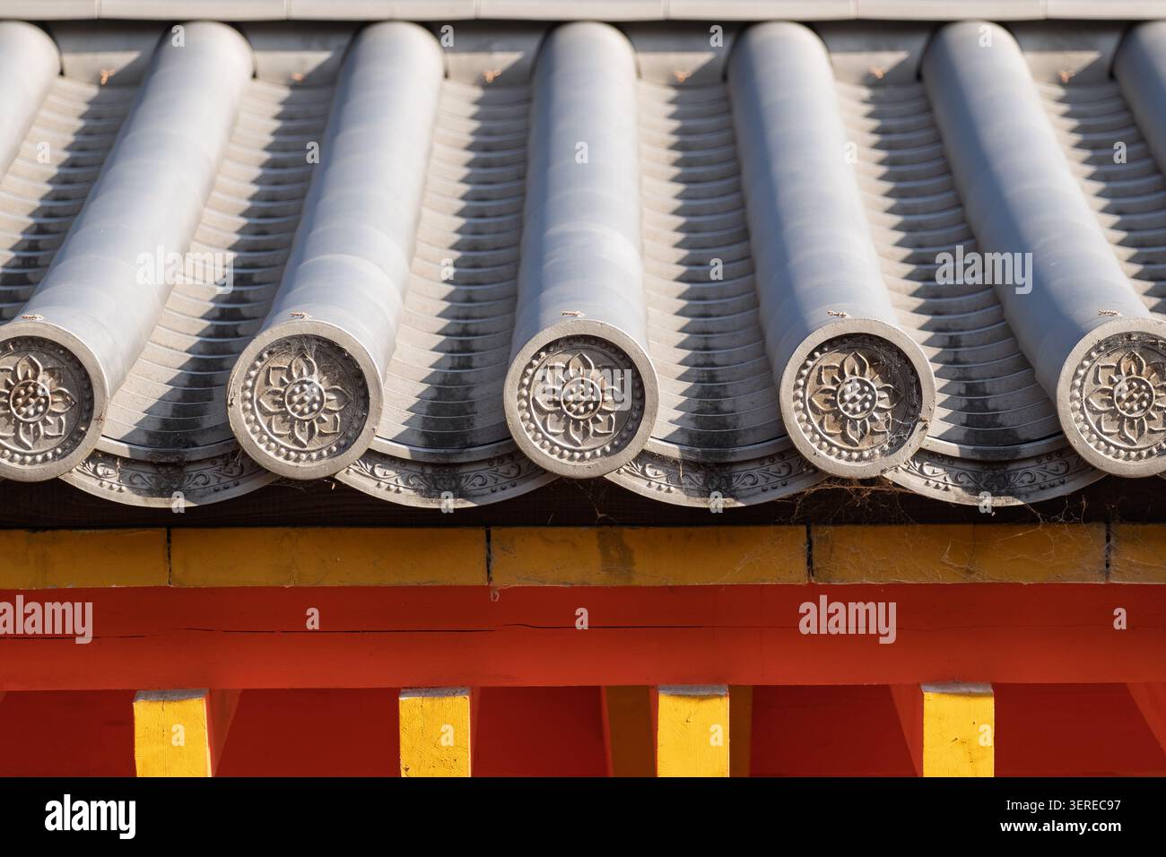 Eine Reihe gekrümmter grauer Lehm-Dachziegel zeigt ein ordentliches geometrisches Wiederholungsmuster auf einem Schrein-Gebäude in Kyoto, Japan Stockfoto