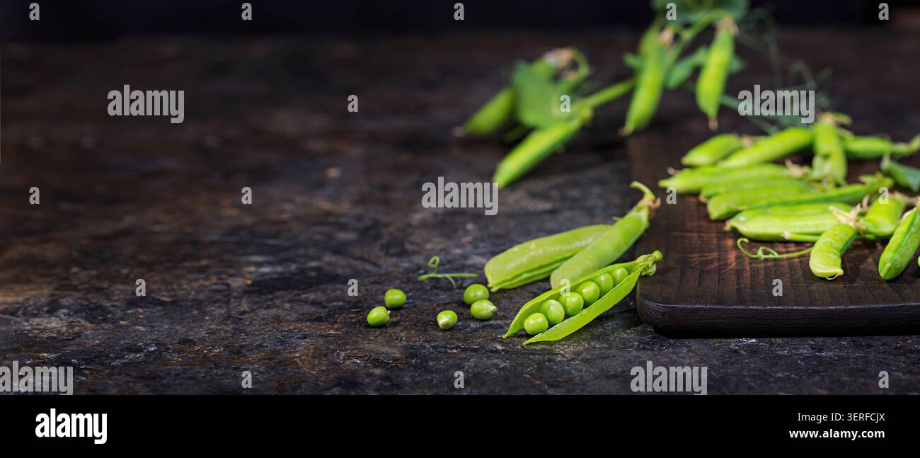 Ländliche Stillleben, Banner horizontal - Ansicht der Erbse Ernte, selektiver Fokus, Nahaufnahme auf einem dunklen Hintergrund mit Platz für Text. Das Erntekonzept Stockfoto