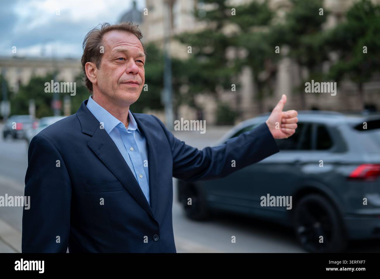 Der Reisende in einem Business-Anzug sucht eine Fahrt für seine Reise Stockfoto