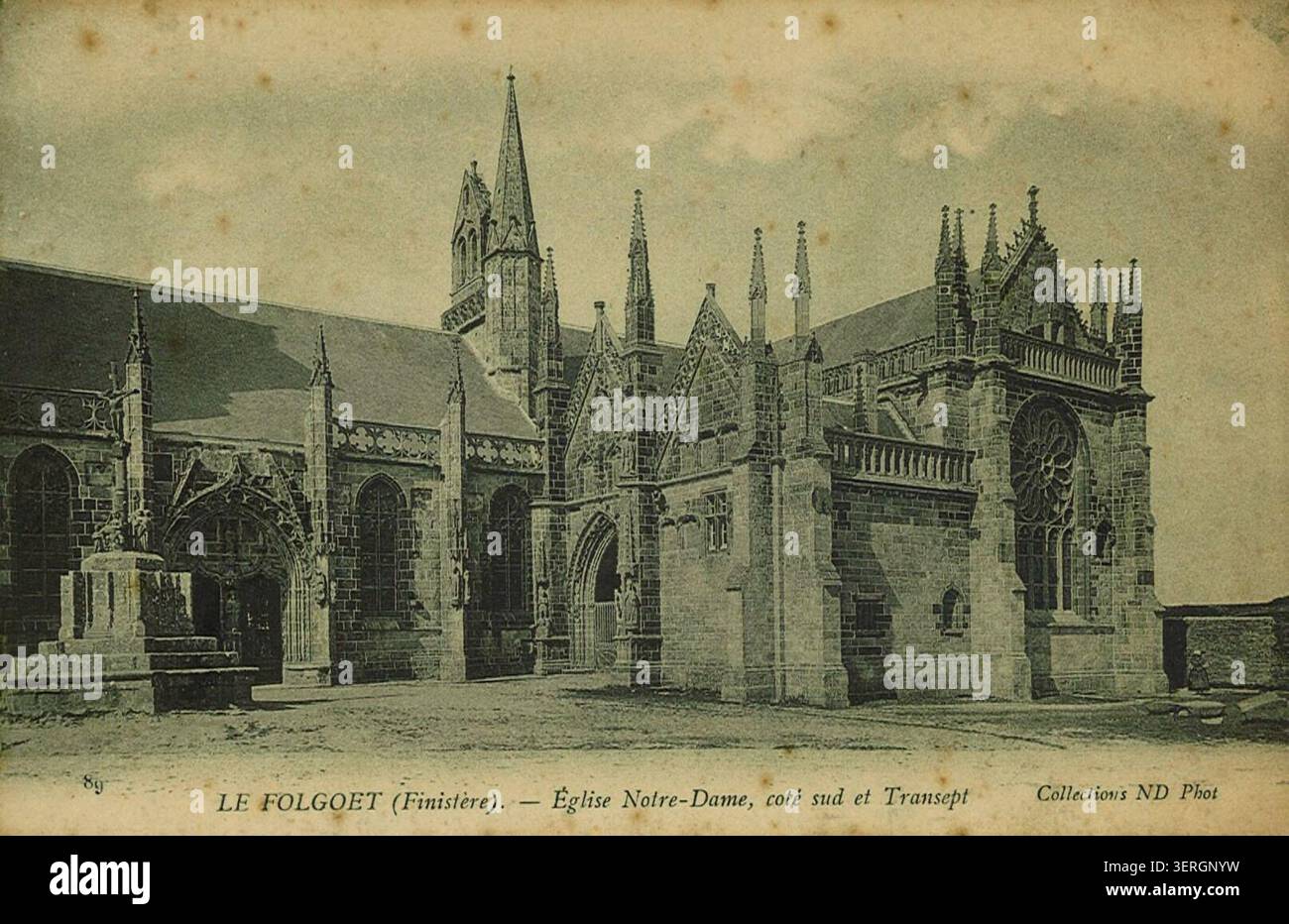 Eine Südseite und ein Querschiff der Eglise Notre-Dame stehen in Le Folgoët, Finistère, die regionale gotisch inspirierte Kirchenarchitektur und ihre Rolle im bretonischen religiösen Leben und der Gemeindeidentität in der ländlichen Bretagne präsentieren. Stockfoto