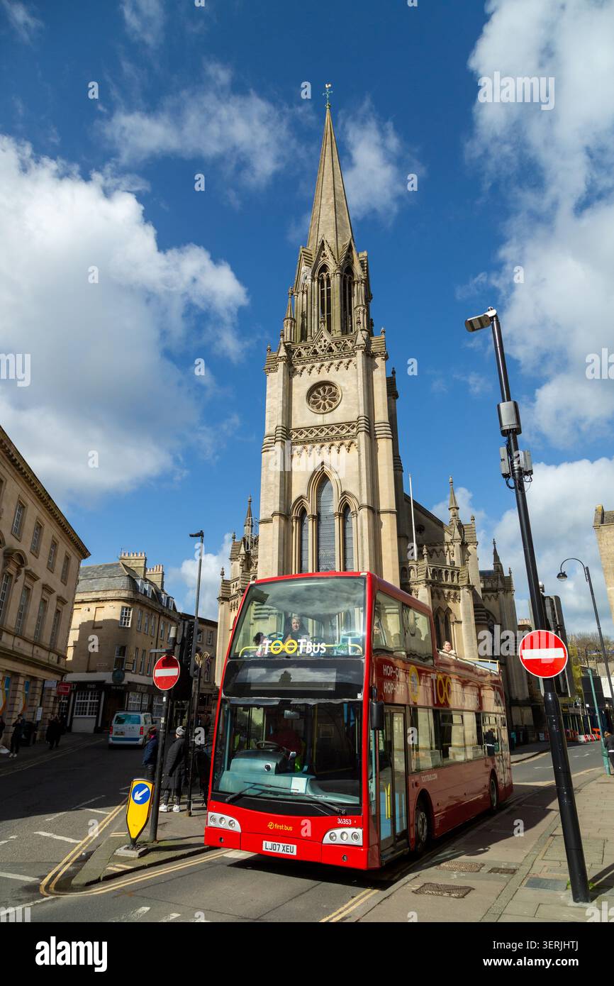 Ein Tootbus Bath mit offenem Oberdeck vor der St. Michael's Church, einer Kirche im gotischen Stil aus dem 19. Jahrhundert, Bath, Somerset. Stockfoto