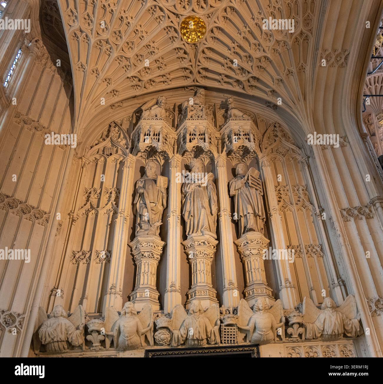 Panoramablick auf geschnitzte Steinstatuen in einer gotischen Wandnische unter einer Fächergewölbedecke in Westminster Abbey, London. Stockfoto