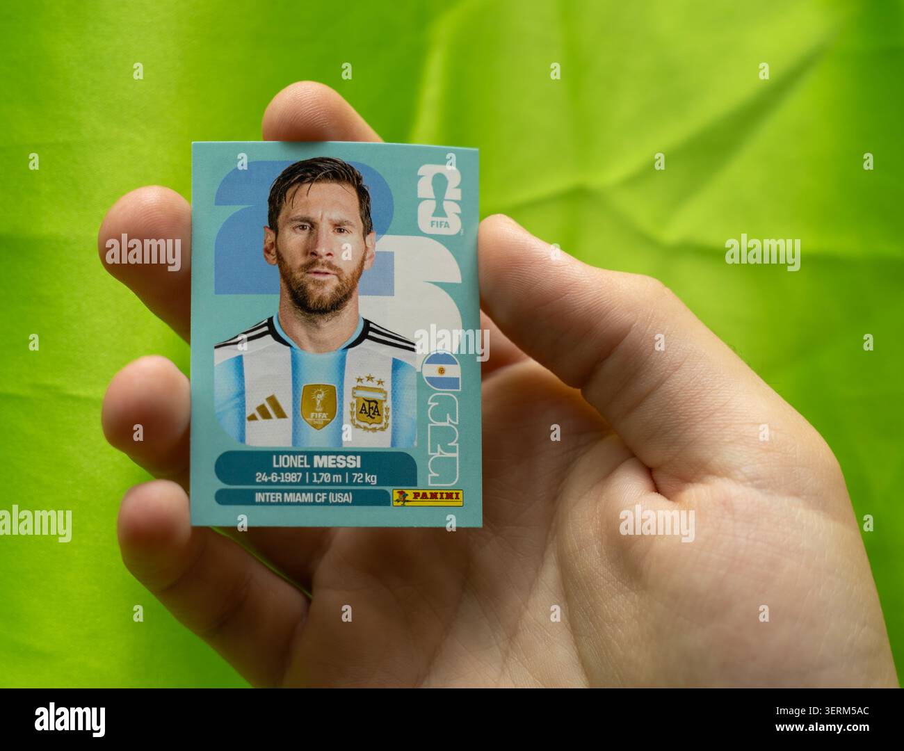 Hand mit einem Panini-Aufkleber zum Sammeln des Fußballspielers lionel messi in argentinien-Trikot Stockfoto