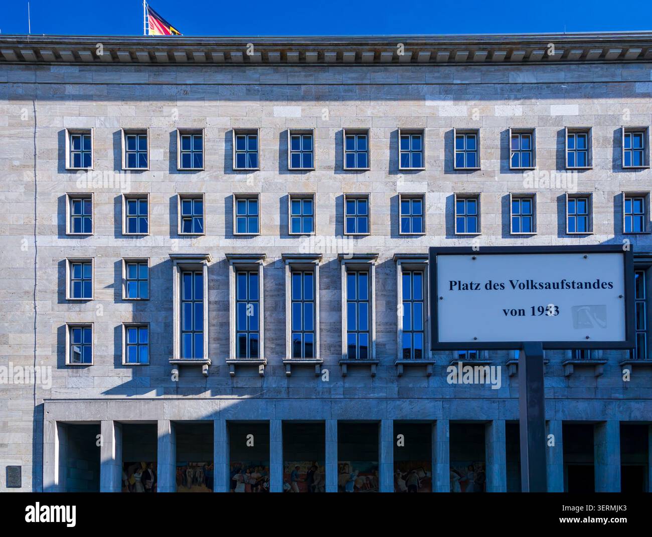 Straßenschild Platz des Volksaufstandes von 1953 mit dem historischen Gebäude des Bundesministeriums für Finanzen in Berlin. Platz Des Völkeraufstands. Stockfoto