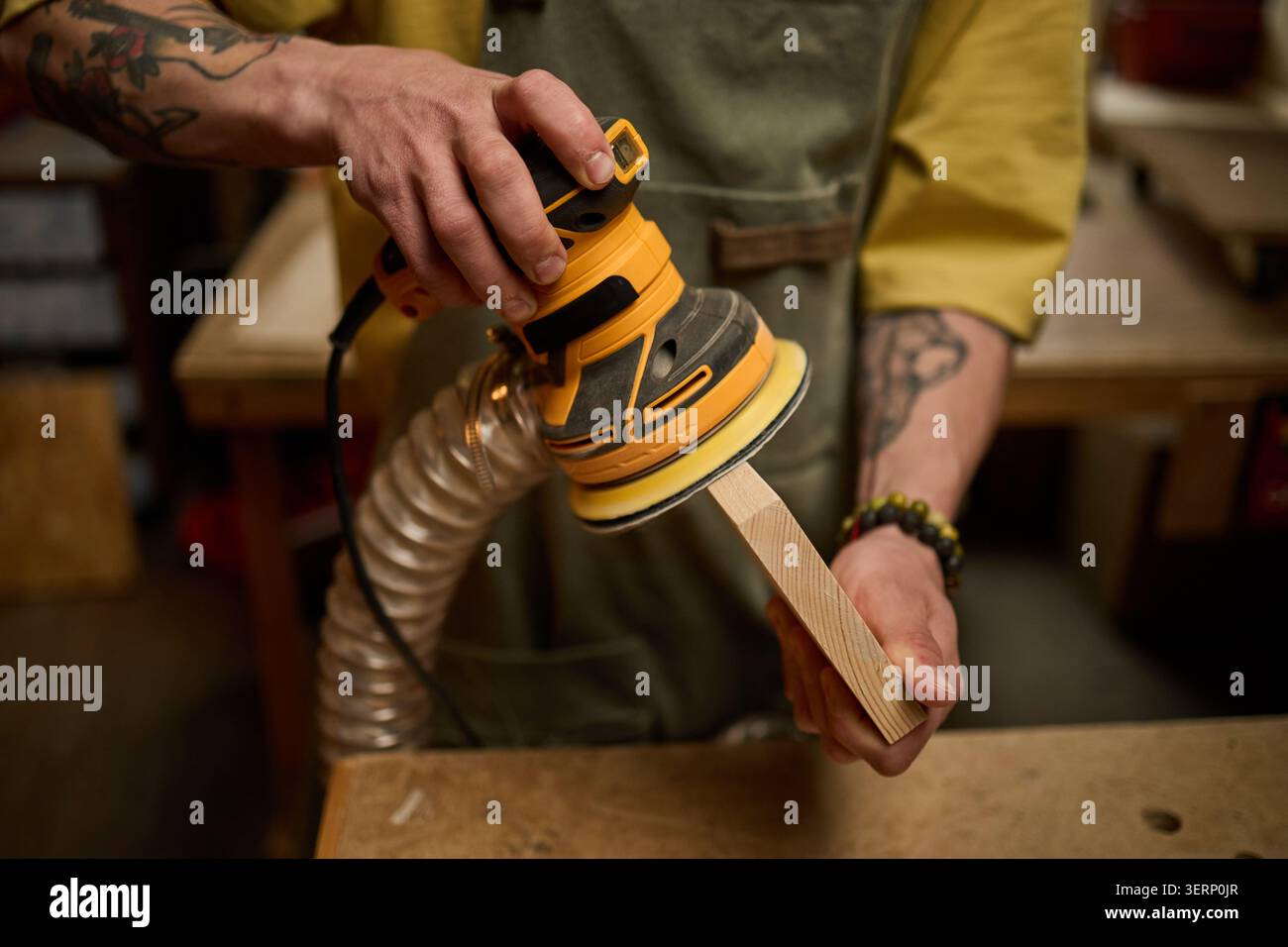 Erwachsener Mann, der Holzkante in der Tischlerei zum Finishing anschleift Stockfoto