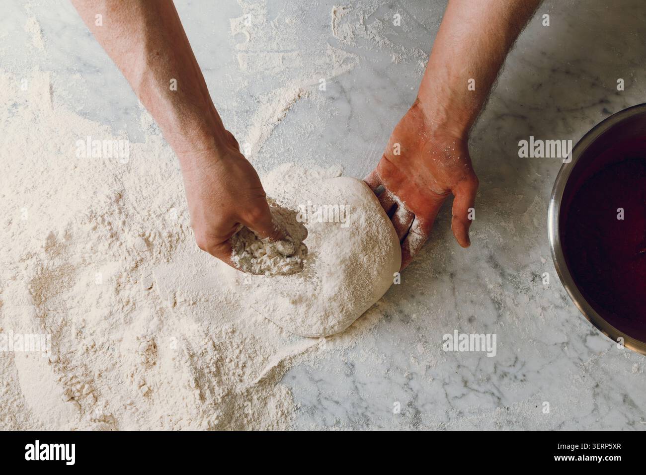 Der Pizzabereiter knettet Teig und formt die Pizzaform Stockfoto