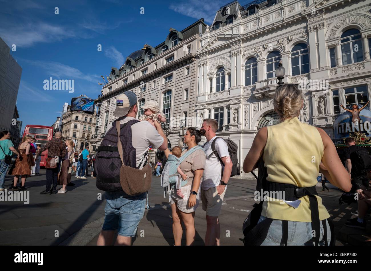 Ausländische Touristen besichtigen den Piccadilly Circus während einer Mini-Hitzewelle, die die Temperaturen in der Londoner Hauptstadt auf über 30 Grad erhöht. Stockfoto