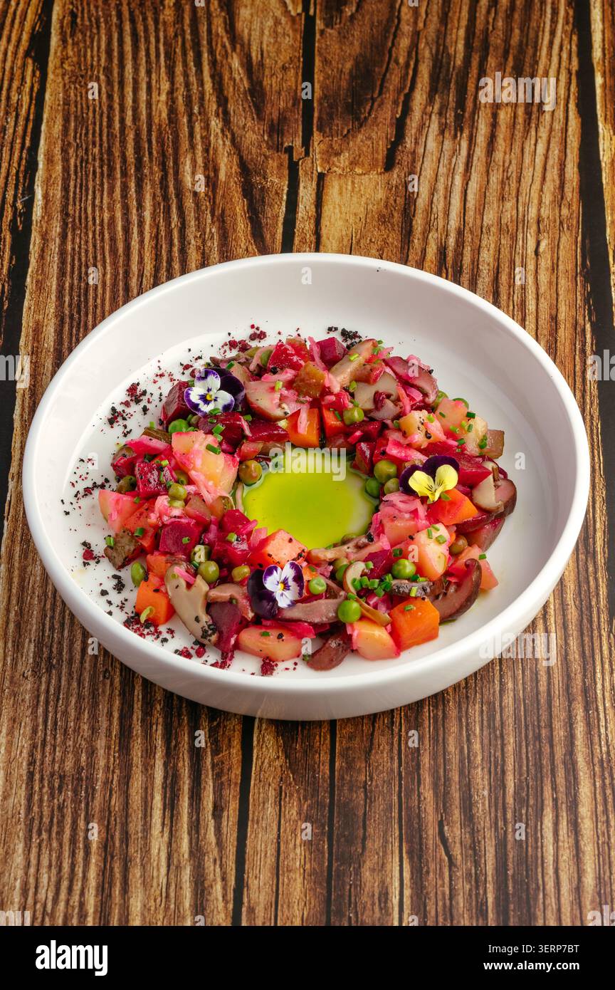 Kunstvoll überzogener Rüben-Salat auf einem rustikalen Holztisch Stockfoto