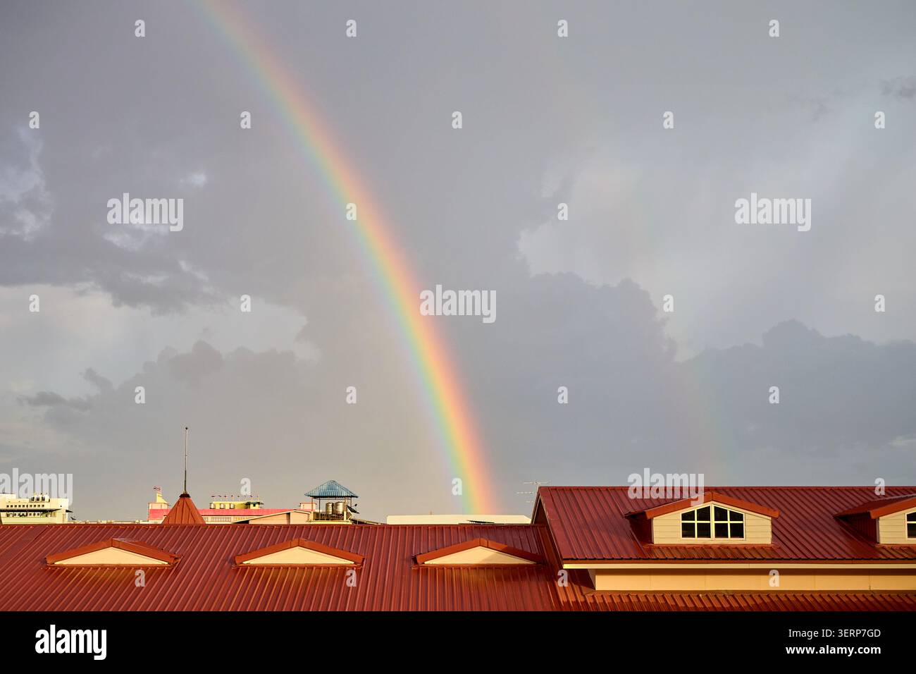 Regenbogen über Wohngebäuden mit roten Dächern Stockfoto