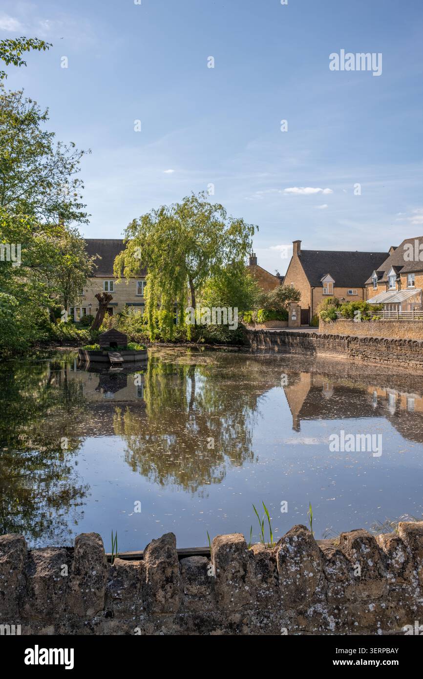 Cotswolds Teich, umgeben von einer traditionellen Steinmauer in einer ruhigen Umgebung Stockfoto