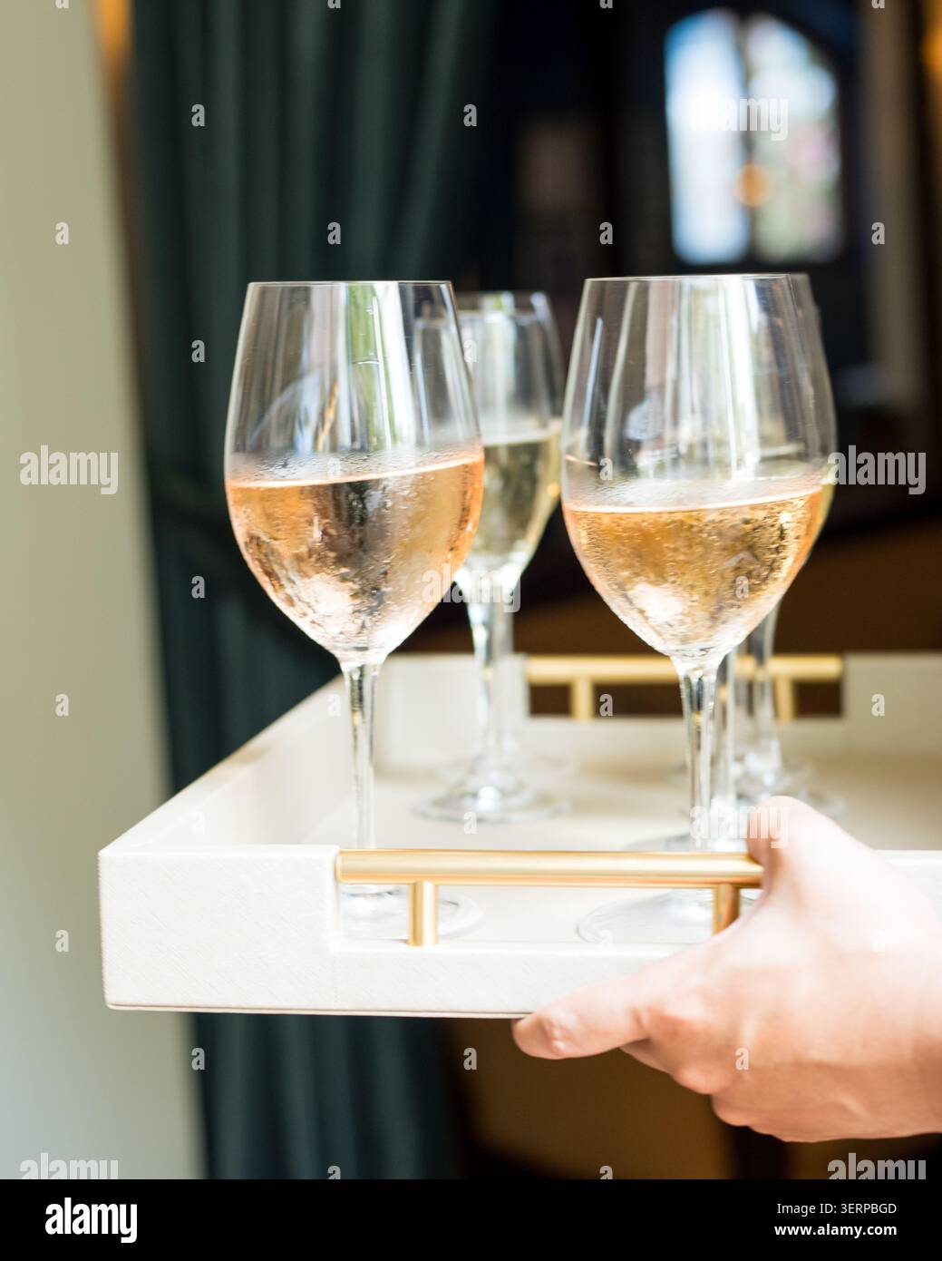 Person, die ein Tablett mit gekühltem rosÃ-Wein trägt Stockfoto