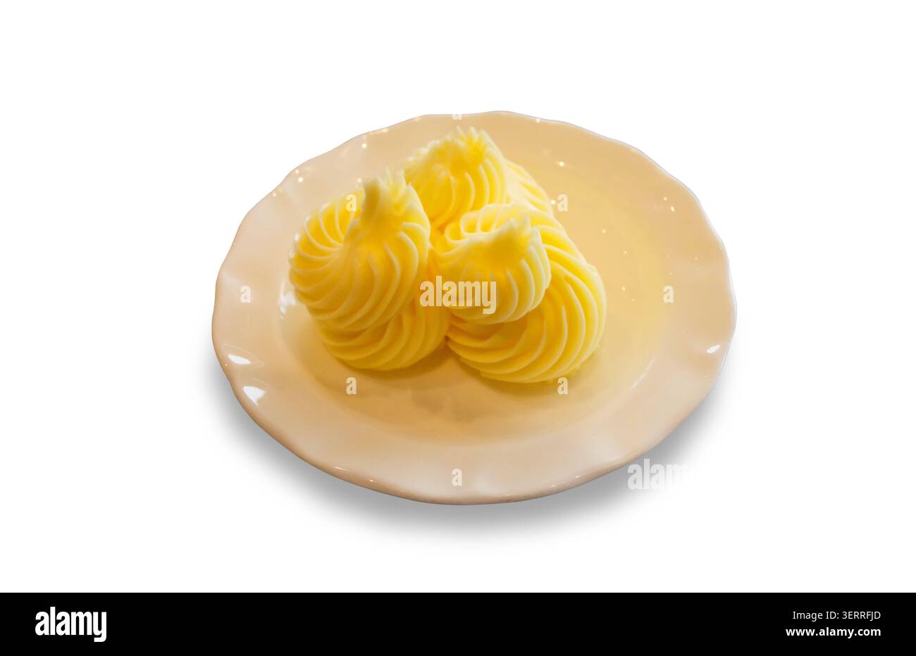 Nahaufnahme von dekorativen Butterwirbeln, die auf einer kleinen Keramikplatte serviert werden. Studio-Aufnahme auf weißem Hintergrund. Stockfoto