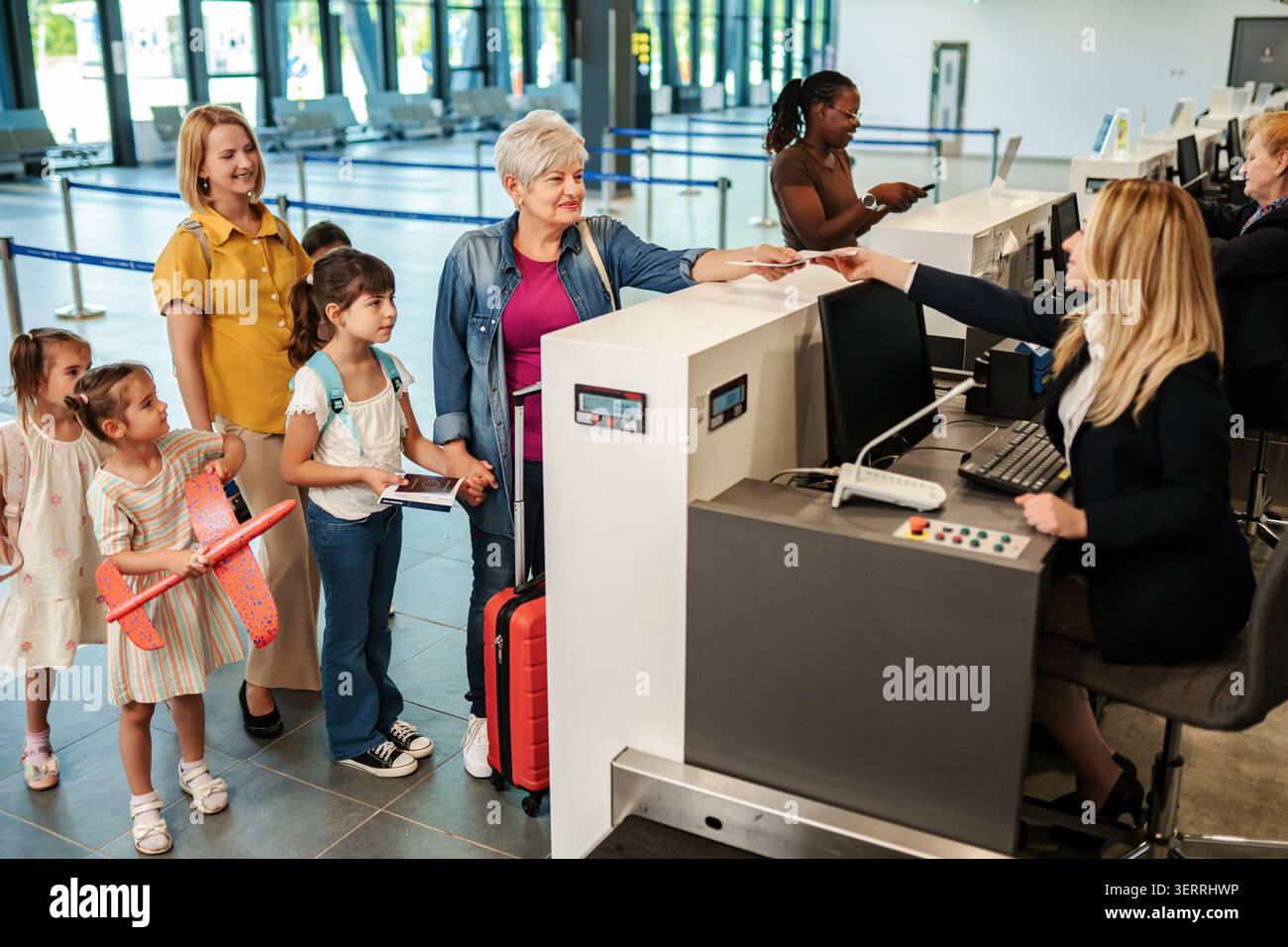 Familien mit mehreren Generationen, die am Flughafen für Urlaub einchecken Stockfoto