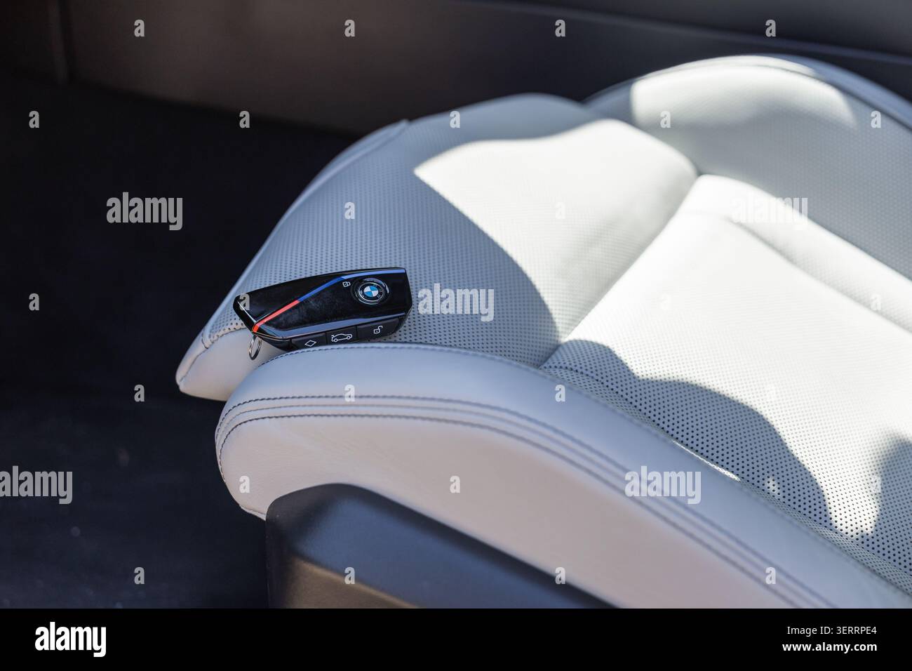 Ljubljana, Slowenien - 8. April 2026: BMW-Schlüssel liegt auf dem Sitz eines Luxusautos mit klarem Design auf. Stockfoto