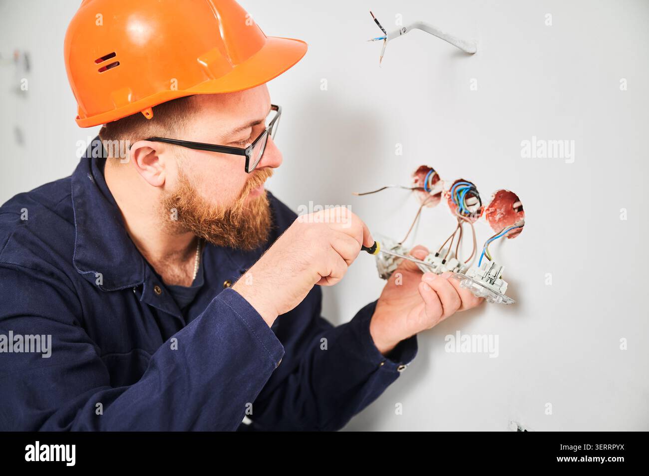 Spezialisierter Einbau von Steckdosen und Anpassen der Verkabelung in Wandöffnungen. Innenbauarbeiten, Elektroinstallation und Upgrade-Konzept Stockfoto