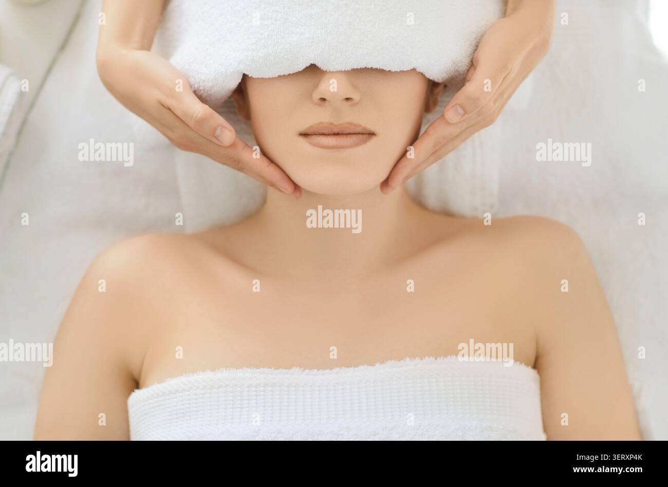 Frau genießt angenehme Gesichtsmassage, fühlt sich entspannt Stockfoto