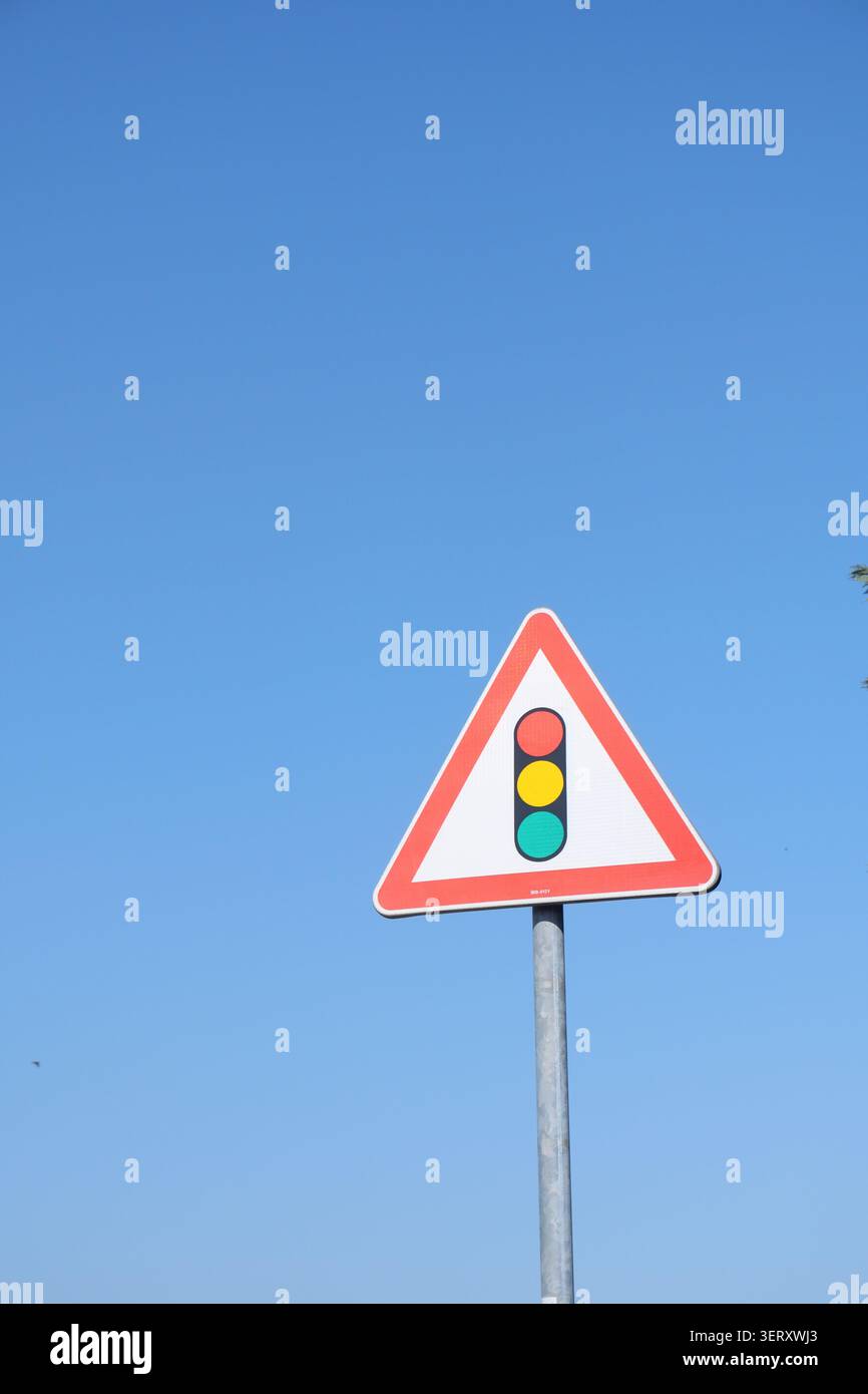 Ampelschild auf der Straße unter blauem Himmel Stockfoto