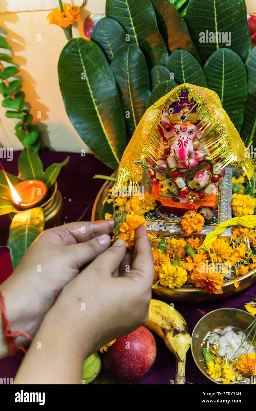 Frau Hand, die das ganesha-Kultritual im Heimtempel auf dem ganesh Chaturthi-Festival vorführt Stockfoto