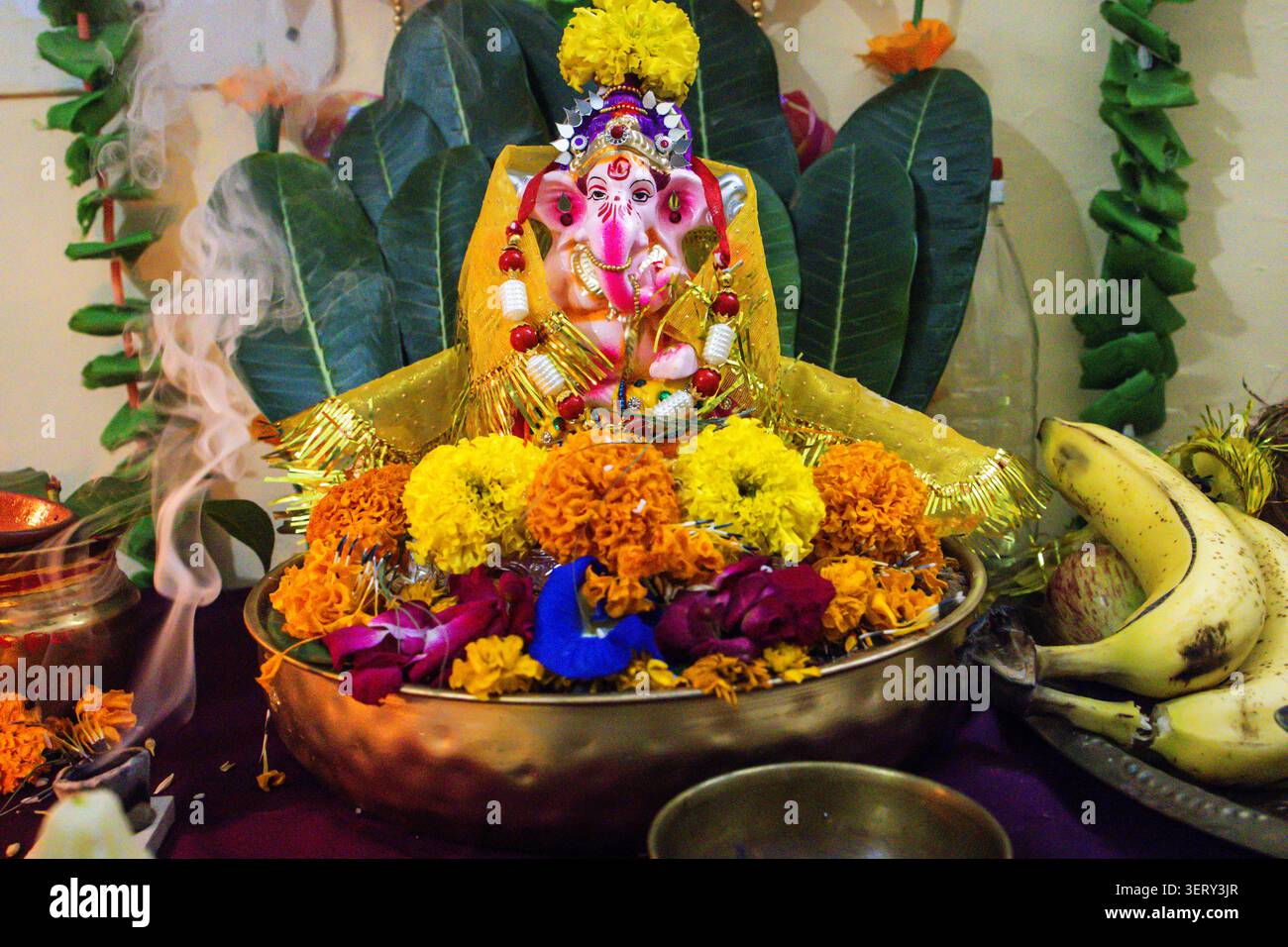 Traditionelle indische ganesha-Puja-Szene mit Blumenopfern und heiligen rituellen Gegenständen Stockfoto