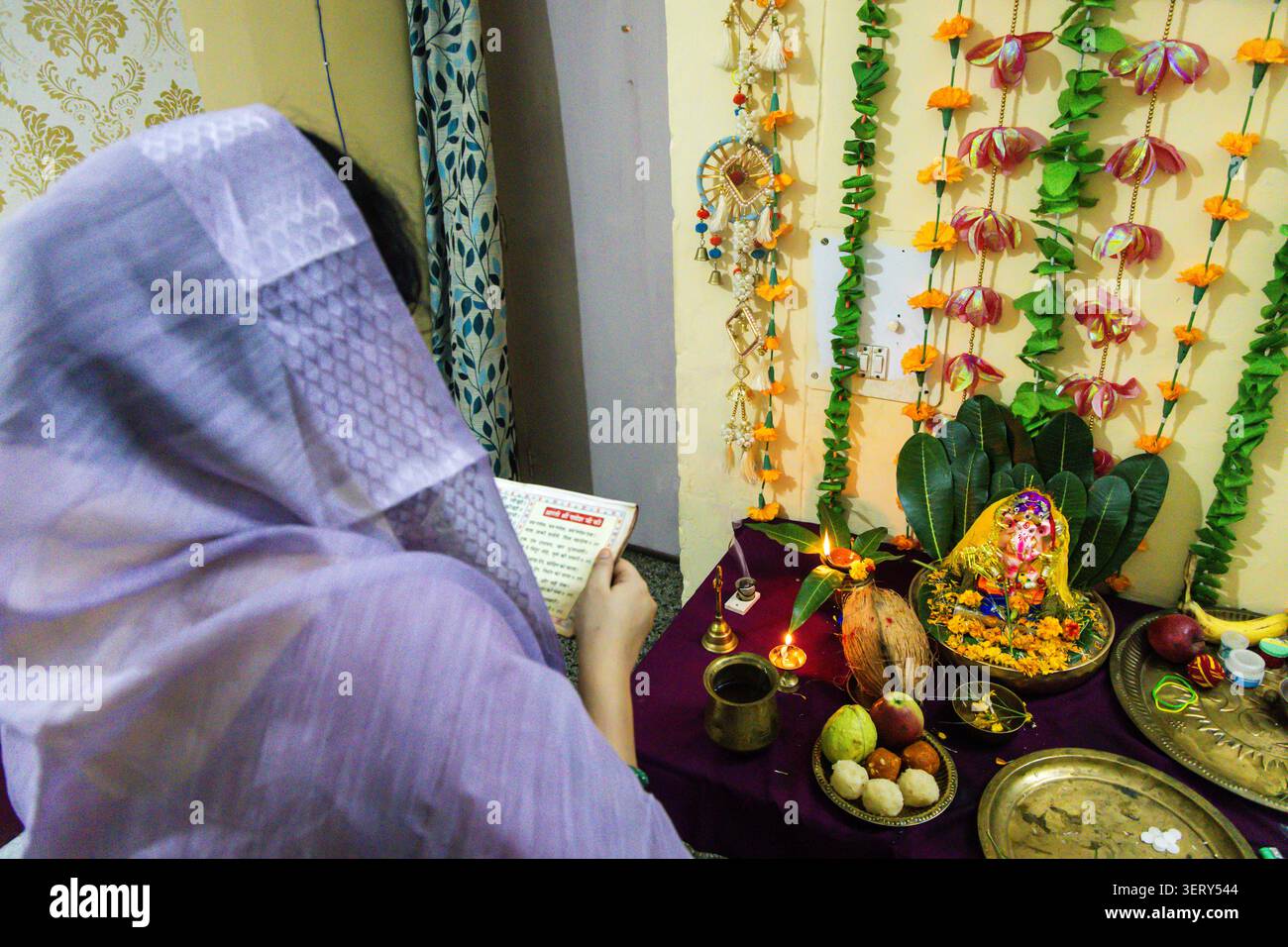 Frau, die ganesh Puja im Tempel vorführt, mit einem Gebetsbuch Stockfoto