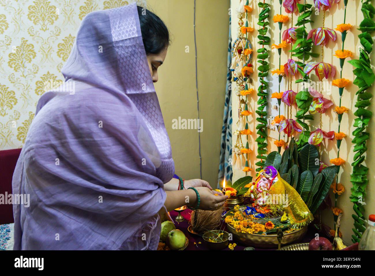 indische Frau, die aarti-Gebete an den geschmückten Herrn ganesha-Idol im Tempel anbietet Stockfoto