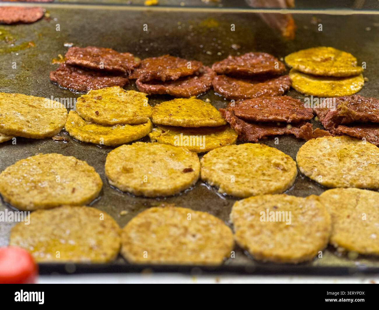 STREET BURGER PATTY AUF DEM BÜRGERSTEIG - Smartphone-aufgenommenes Stockfoto